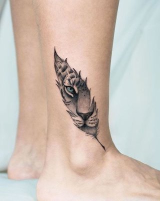 Tatouage plume sur la cheville avec une tête de félin